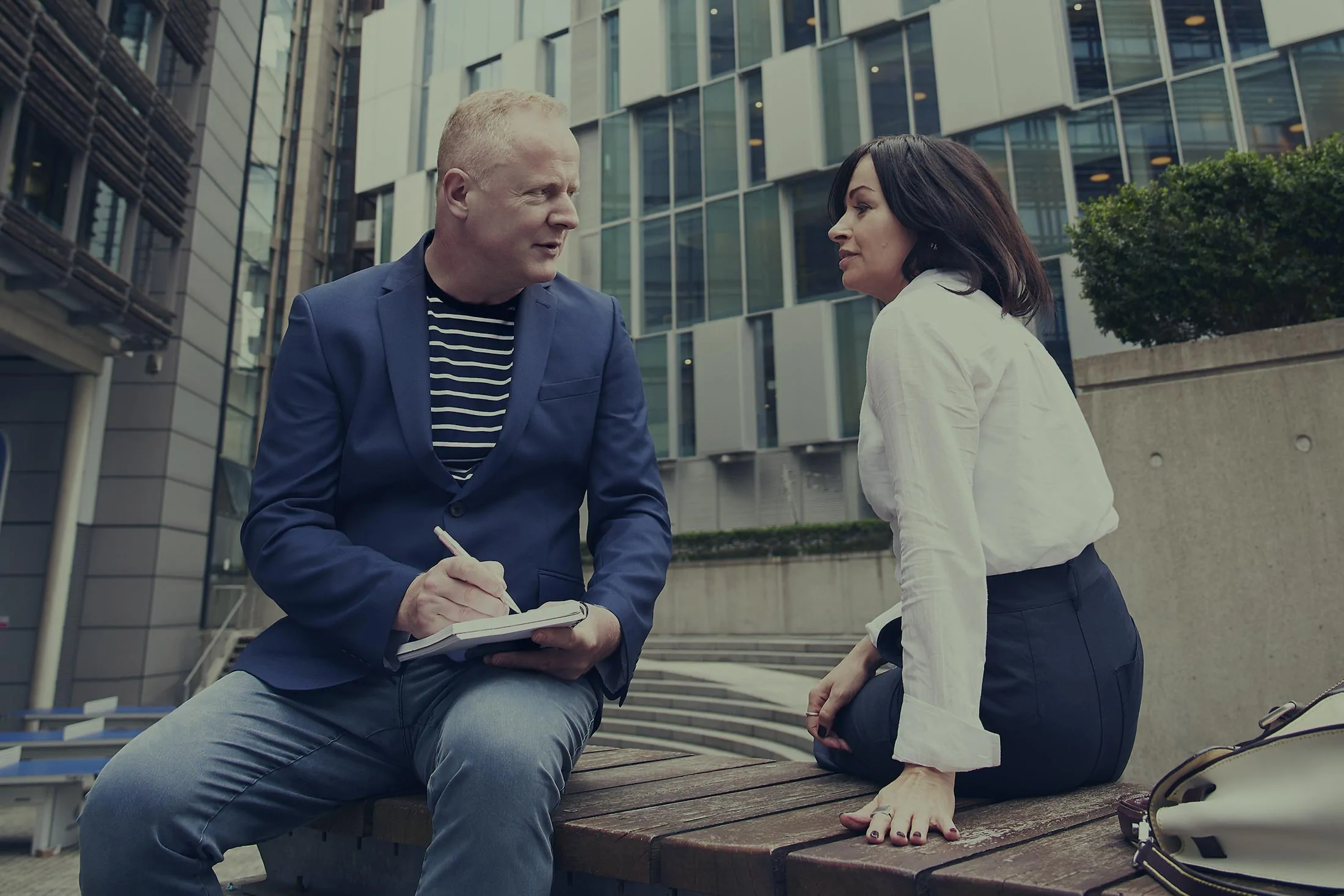 Man and woman talking on an outdoor bench