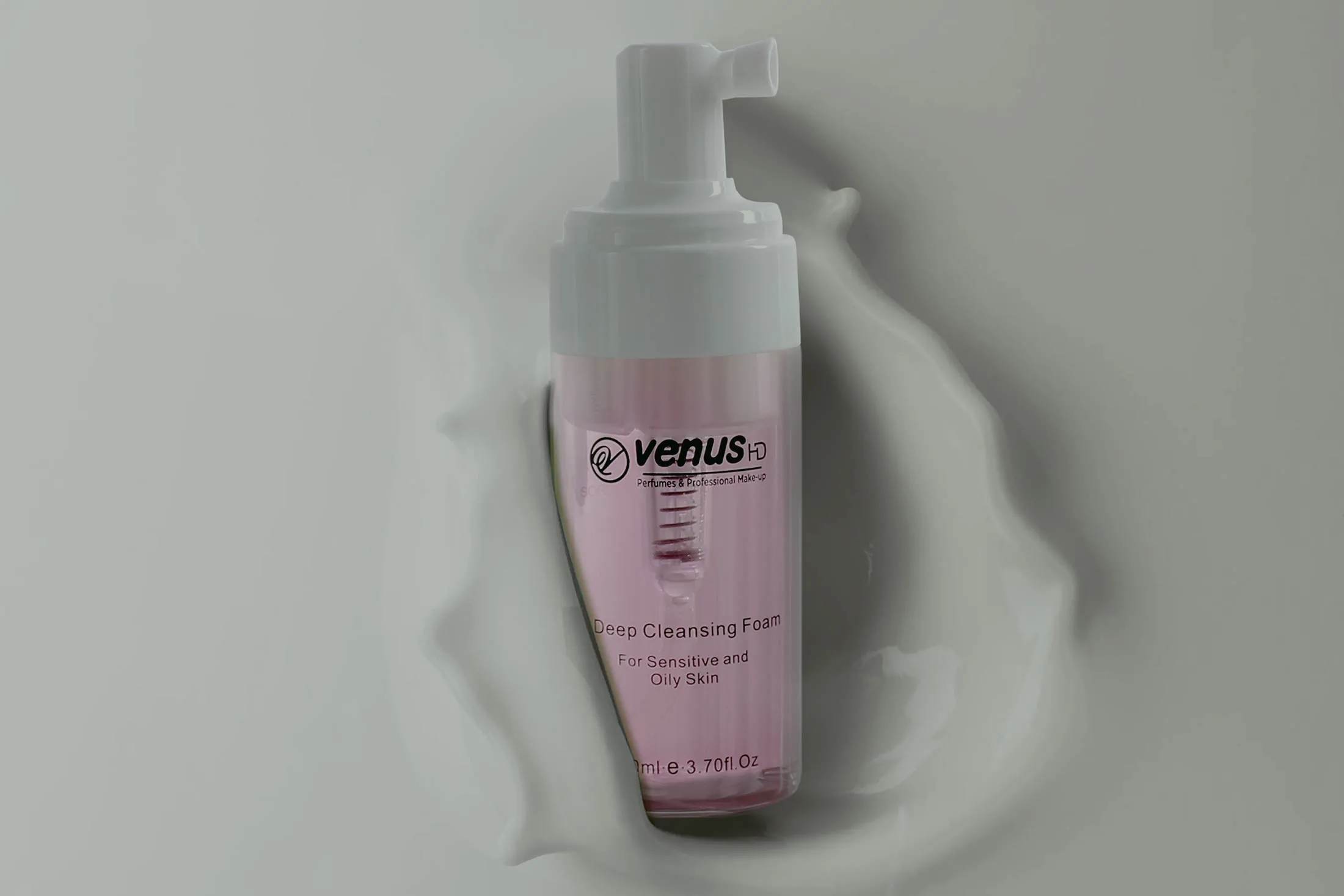 Pink cosmetic pump bottle on a soft background