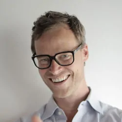 Headshot of a smiling man with glasses