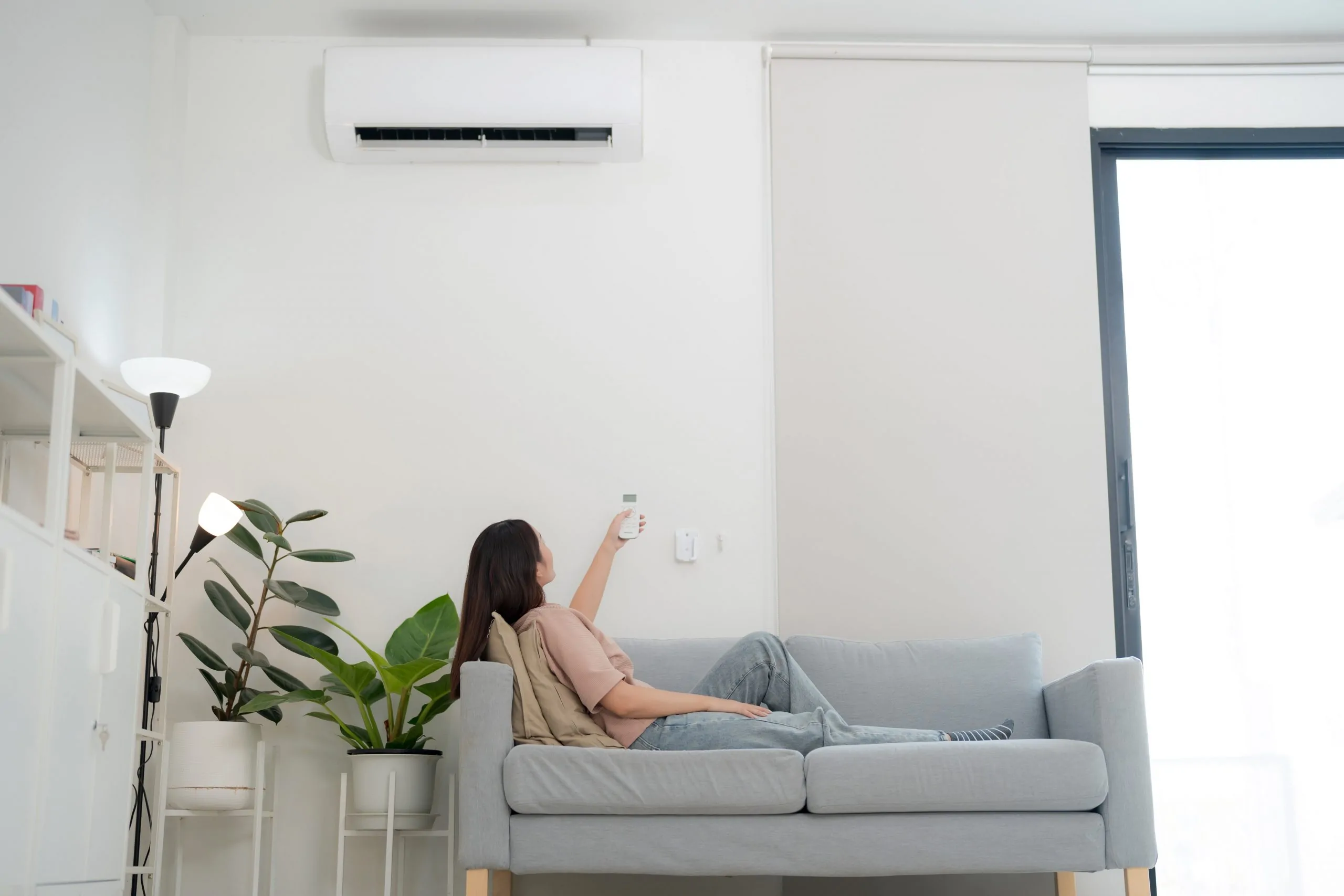 Jeune femme profitant de la climatisation à la maison